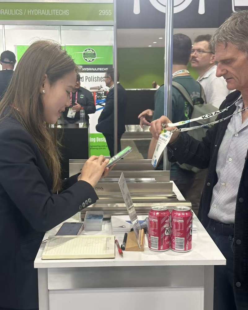 Visitor exchanging details with the Fabmax team at AMW 2026